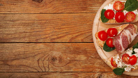Italian appetizer. Bruschetta on a wooden board on a wooden rustic backgroundの写真素材