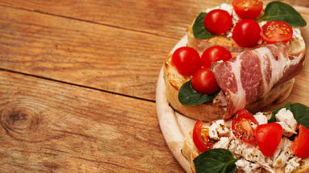 Italian appetizer. Bruschetta on a wooden board on a wooden rustic backgroundの写真素材