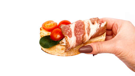 Bruschetta on ciabatta in hand on a white background. Italian appetizer isolatedの写真素材