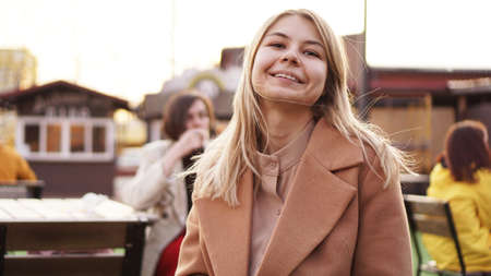 Portrait of a young woman in the city. City food court with street food. Portrait of a smiling blonde. Lifestyle photoの写真素材