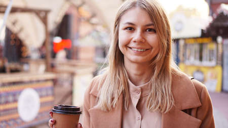 Young blonde with a cup of coffee. Woman at the food court. Lifestyle photo. Beautiful woman drinking coffeeの写真素材
