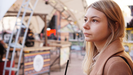 Portrait of a young woman in the city. City food court with street food. Portrait of a blonde. Lifestyle photoの写真素材