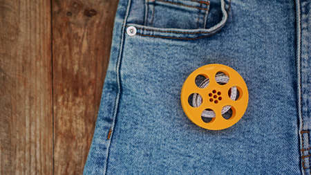 Blue jeans and a measuring tape. Slimming or sewing denim concept. Jeans on wooden backgroundの写真素材