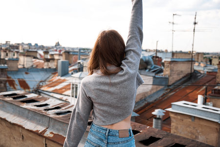 Woman is happy on the roof of Saint Petersburg, Russia. Cityscape view over the rooftops of St. Petersburg.の写真素材