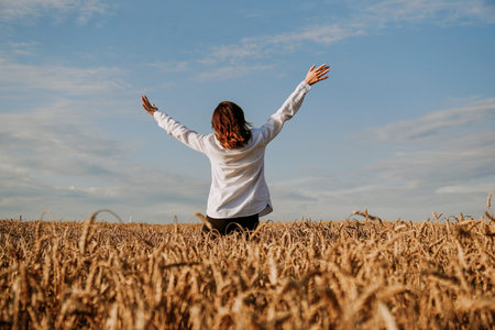 A woman in a white shirt in a rye field. View from the back. The concept of pacification,...