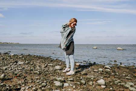 Young woman in sunglasses wrapped in a scarf, autumn on the Gulf of Finland, St. Petersburgの写真素材