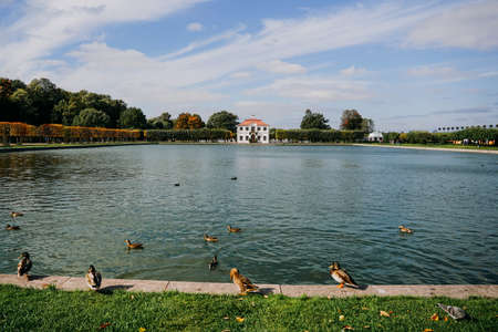 Tourism and architecture. Old vintage house on the background of beautiful scenery with a pool with cloudy sky. Peterhof, Russia. September 20, 2021のeditorial素材