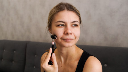 Closeup beauty portrait. Derma roller. Beautiful woman with mezoroller. Exercises for face, neck,...