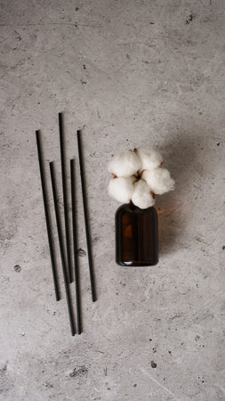 Transparent bottle of aroma diffuser. Parfum for home with cotton flowers. Trending concept, natural...