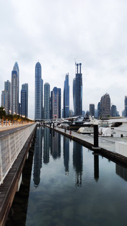 Yachts and boats in Dubai Marina, United Arab Emirates. Vertical photo, view of skyscrapers near the pierの写真素材