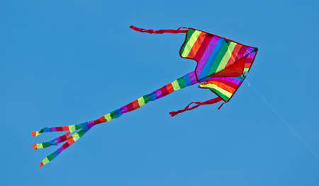 A beautiful, colorful stunt kite, in the blue sky, high up in the windの写真素材