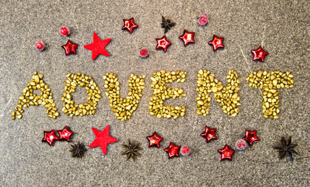 The word? Advent? laying on the ground, golden pebbles and some festive decoration