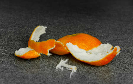 The orange paring of a tangerine, laying on a table, no slice is leftの写真素材
