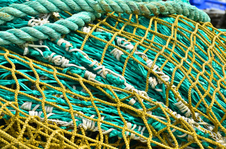 A heap, a huddle of traditional fishing equipment with green nets and orange buoys