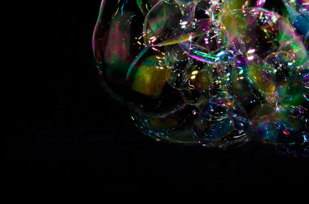 Beautiful bubbles of soap in front of black background, bright and glossy