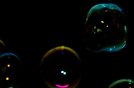 Beautiful bubbles of soap in front of black background, bright and glossyの写真素材