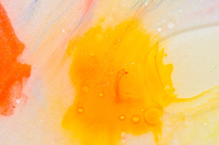red, orange, yellow, brown white and gold liquid bright aquarel colors with oil generate fluid structures and bubbles inの写真素材