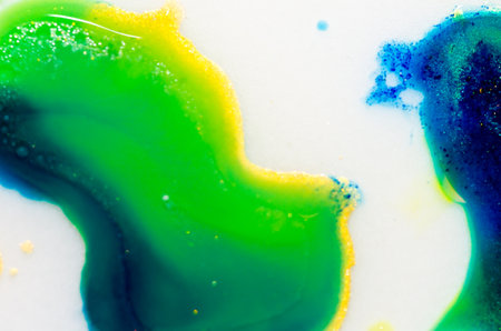 Liquid bright aquarel colors with oil generate fluid structures and bubbles in green, blue, yellow, white and goldの写真素材