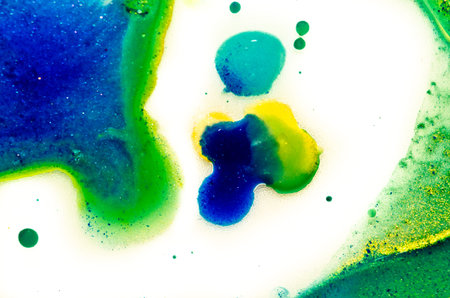 Liquid bright aquarel colors with oil generate fluid structures and bubbles in green, blue, yellow, white and goldの写真素材