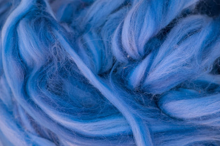 Blue wool yarn as a background. Macro photo with selective focus.