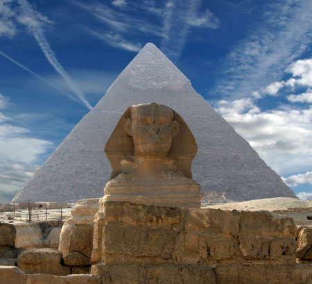 Sphynx and pyramid on a background of the cloudy sky