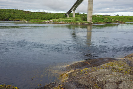 At the base of the Saltstraumen bridge with the tidal current gushing through the channelの写真素材