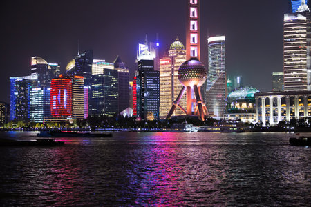 Editorial: SHANGHAI, CHINA, April 16, 2019 - View of the Oriental Pearl Tower with barges on the Huangpu River at night in Shanghaiのeditorial素材