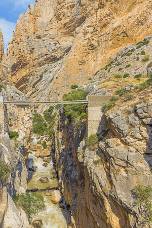 Editorial: CAMINITO DEL REY, ARDALES, ANDALUSIA, SPAIN, OCTOBER 1ST, 2021 - A bridge over the Guadalhorce gorge with the King's pathway in the background with some tourists discovering the restored pathのeditorial素材