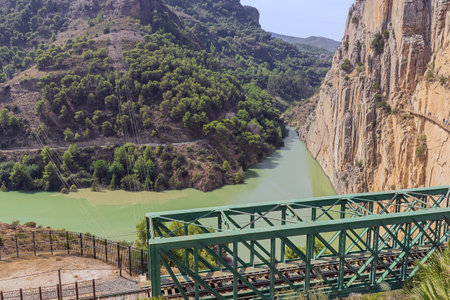 Editorial: CAMINITO DEL REY, ARDALES, ANDALUSIA, SPAIN, OCTOBER 1ST, 2021 - The Tajo de la Encantada reservoir with the railway bridge at the end of the King's pathwayのeditorial素材