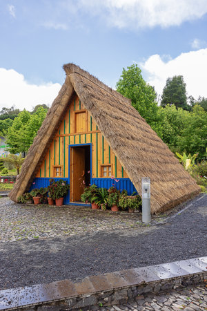 Blue and yellow Santana style house with high thatch roofsの写真素材