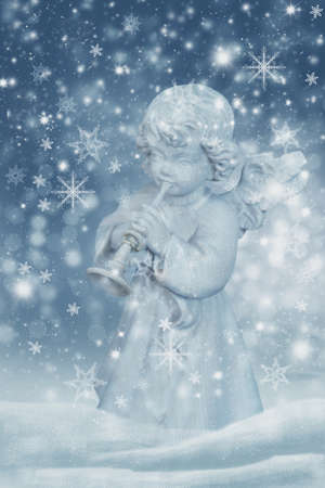 Christmas angel making music in the snowfallの写真素材