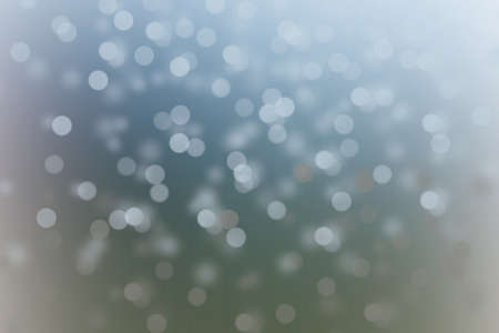 Defocused abstract blue christmas background. Snow is falling down vertical shot. Blue water drops backgroundの写真素材