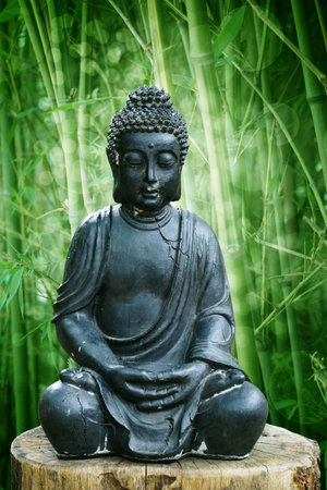 Buddha statue against green bamboo backgroundの写真素材