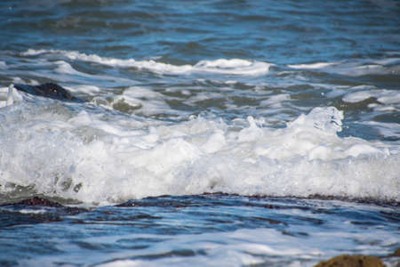 Sea wave foam on the beach in Estepona, Andalucia, Spain. Peaceful ocean waves at beach.の写真素材