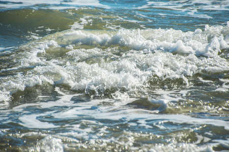 Sea wave foam on the beach in Estepona, Andalucia, Spain. Peaceful ocean waves at beach.の写真素材