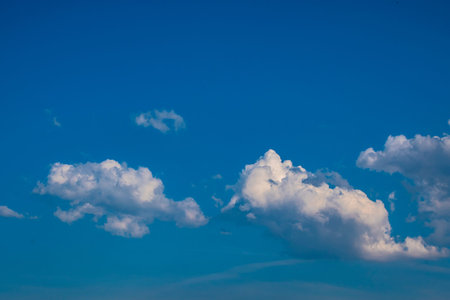 White clouds on the blue sky. Abstract background with clouds on blue sky. In the clear sky high...