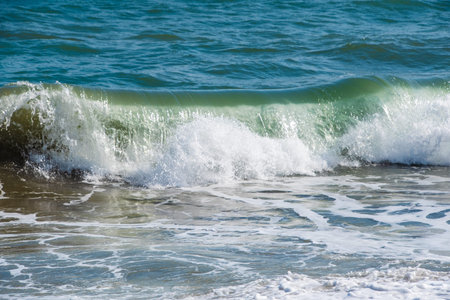 Mediterranean sea at sunset. Waves break on the sandy shore, sea foam. Natural background