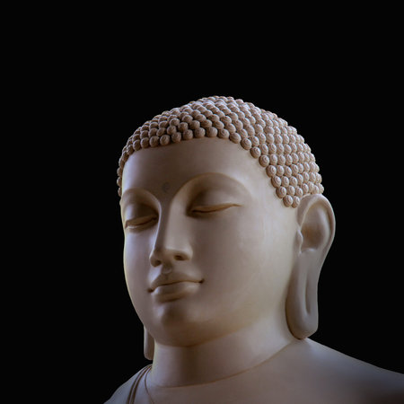 Portrait of a buddha statue, islated on black background. Sign for peace and wisdomの写真素材