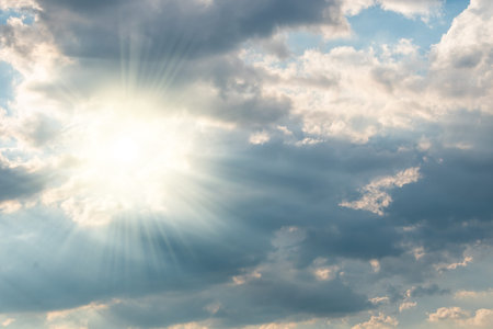 Blue sky background with white dramatic clouds and sunlight, vast sky background