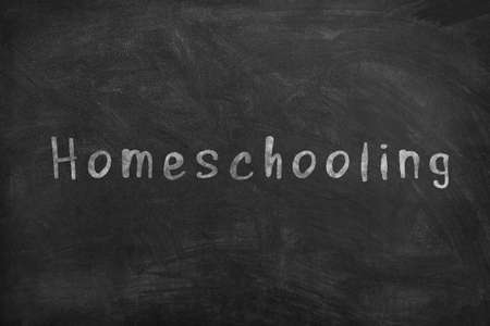 Homeschooling. Word Homeschooling written on an old blackboard.の写真素材