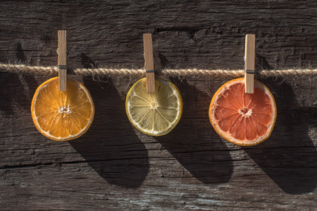 Lemon, lime and grapefruit on clothespins on a wooden backgroundの素材