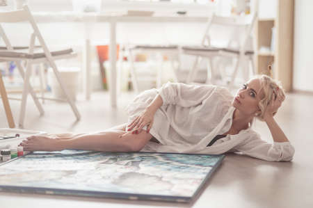 Young woman lying on the floor and posing for the photographerの写真素材