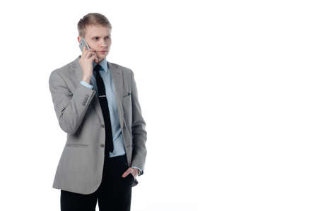 young businessman talking on the phone. in a business suit on a white background.の写真素材