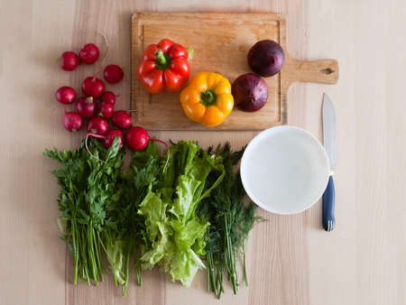 Fresh vegetables laid out on the kitchen table, preparing a salad, top viewの写真素材