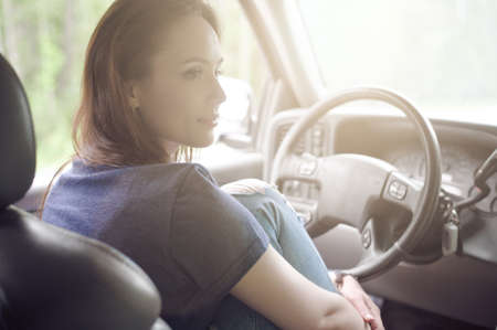 Pretty girl traveler sitting in the car and resting from a long journey in Sunny weatherの写真素材