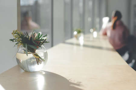 Decor of a small bouquet of flowers in a transparent vase of glass are on the table cafeの写真素材