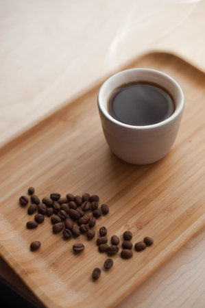 Tray with a Cup of hot coffee and coffee beans, lying on the table in the cafe