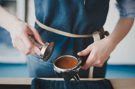 The Barista girl prepares coffee, filling the receiver with ground coffee, pressing and making a...
