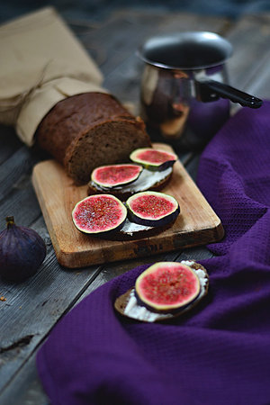 Beautiful Fig sandwiches from black bread lie on a wooden table