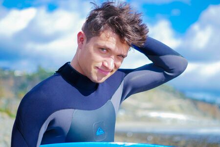 Male model at the beach, surfer wear wetsuit, smileの写真素材
